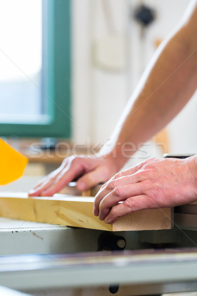 Carpenter using electric saw in carpentry Stock photo © Kzenon