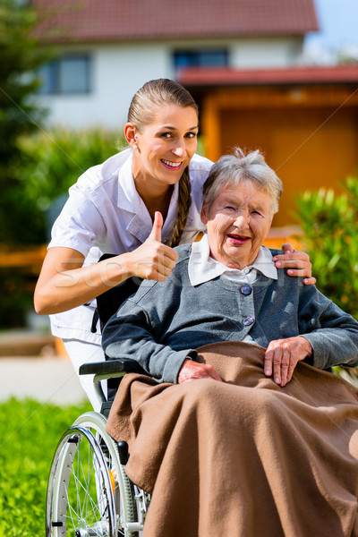 Idős nő öregek otthona nővér kert ül Stock fotó © Kzenon