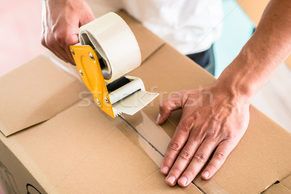 Man taping packing case Stock photo © Kzenon