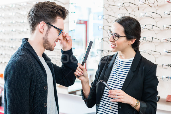 Woman and man buying glasses in optician shop Stock photo © Kzenon
