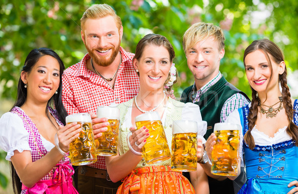 Friends in beer garden with beer glasses Stock photo © Kzenon