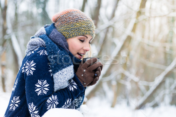 Woman freezing on a cold winter day warming herself up with hot  Stock photo © Kzenon