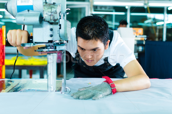 Worker using a machine in chinese factory Stock photo © Kzenon