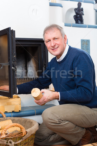 Senior at home in front of fireplace Stock photo © Kzenon