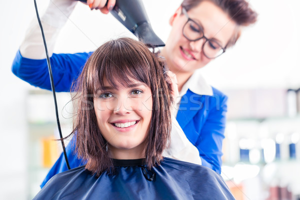 Hairdresser blow dry woman hair in shop Stock photo © Kzenon