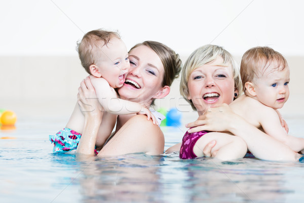 Mothers and their little children having fun at baby swim lesson Stock photo © Kzenon