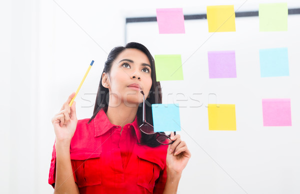 Young employee looking at multiple reminders while planning her  Stock photo © Kzenon