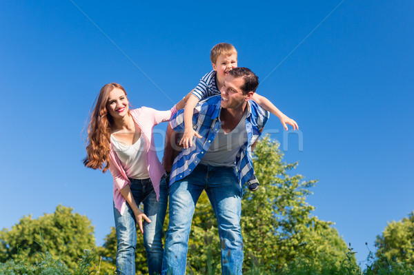 Daddy tragen Sohn huckepack zurück Wiese Stock foto © Kzenon