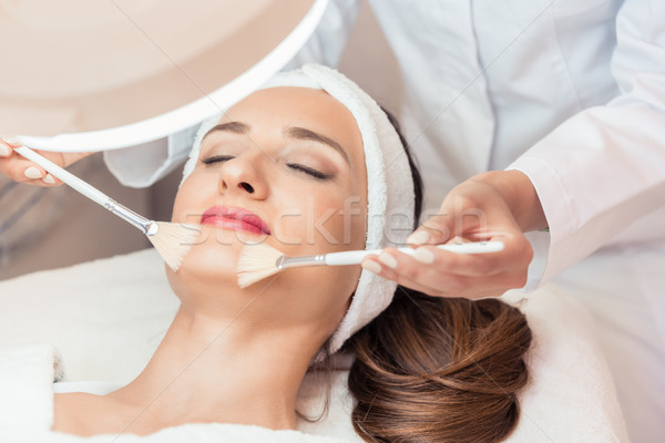 Beautiful woman during anti-aging facial massage in a modern cosmetic center Stock photo © Kzenon