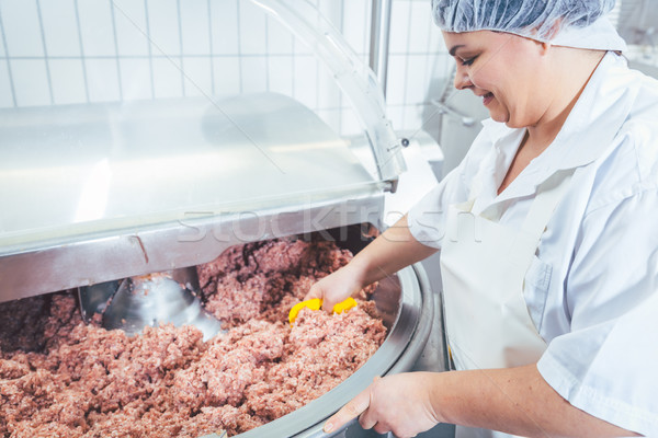 Butcher woman working on meat in butchery Stock photo © Kzenon