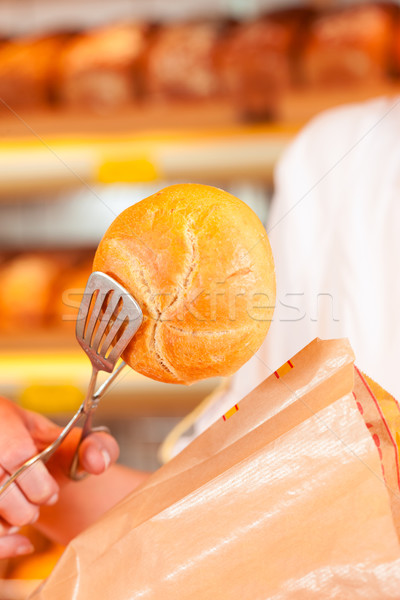 Salesperson is packing bread in bakery Stock photo © Kzenon