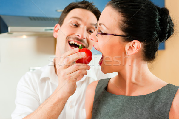Stock photo: Couple cooking together in kitchen
