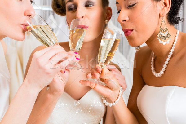 Brides drinking champagne in wedding shop Stock photo © Kzenon
