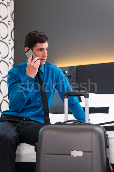 Man telephoning at arrival in hotel room Stock photo © Kzenon