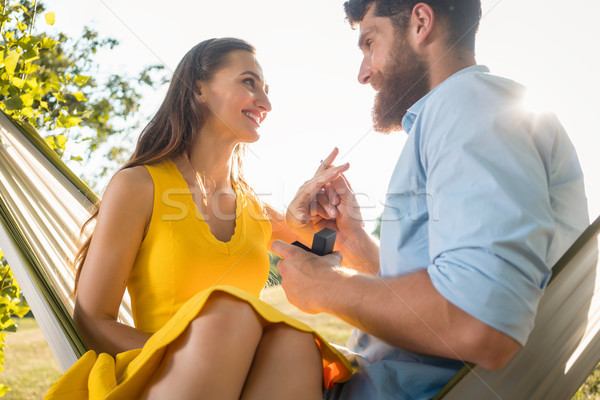 Happy man putting engagement ring on the finger of girlfriend on Stock photo © Kzenon