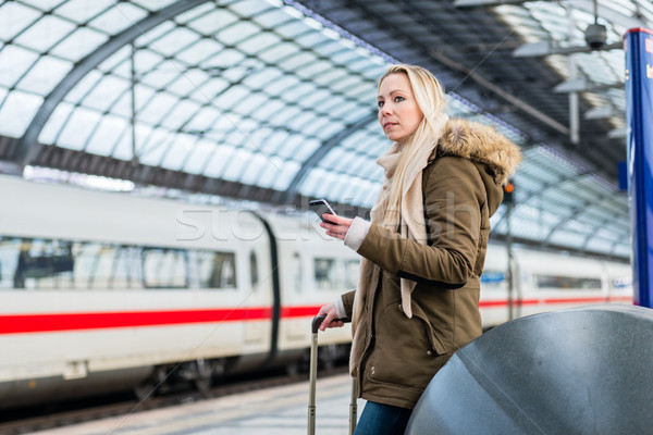 Woman in train station using time table app on phone Stock photo © Kzenon