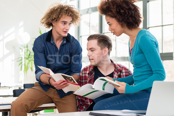 Three students comparing information from two different textbooks Stock photo © Kzenon