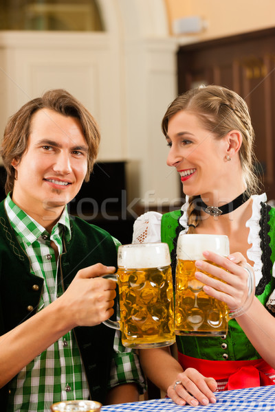 Young couple in traditional Bavarian Tracht in restaurant or pub Stock photo © Kzenon