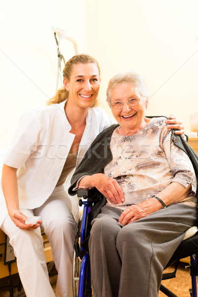 Young nurse and female senior in nursing home Stock photo © Kzenon