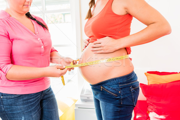 Standing pregnant women and midwife measuring circumference of b Stock photo © Kzenon