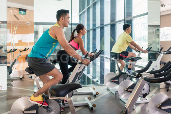 handsome and confident young man during group class of HIIT indoor cycling Stock photo © Kzenon