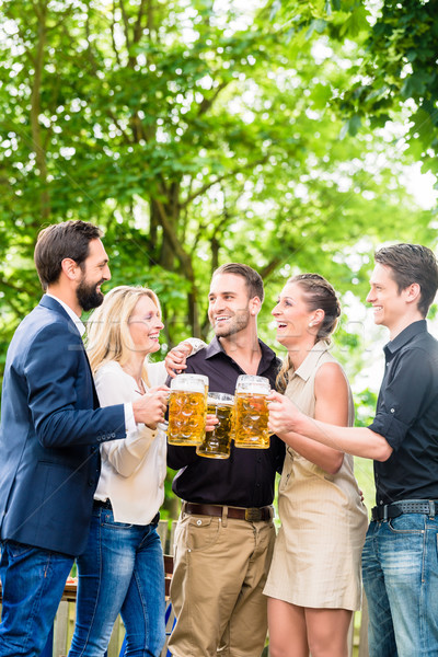 Friends or colleagues on beer garden after work Stock photo © Kzenon