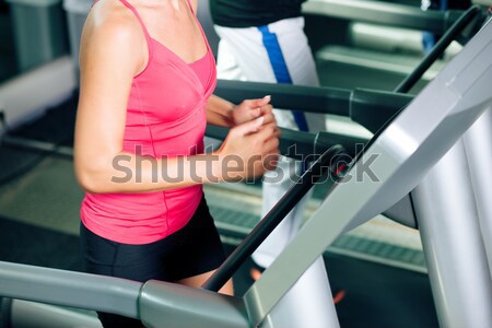 Man training in gym with fitness machine Stock photo © Kzenon