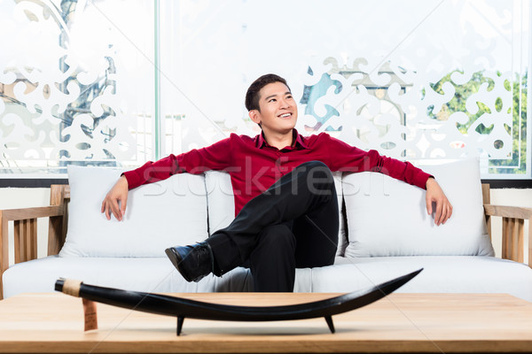 ázsiai férfi ül kanapé bútor bolt Stock fotó © Kzenon