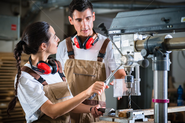 Stock photo: Carpenter woman and man with drill in workshop
