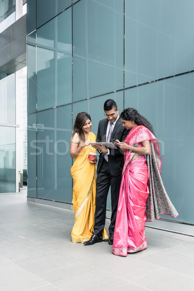 Indian business people using high-tech devices during break Stock photo © Kzenon