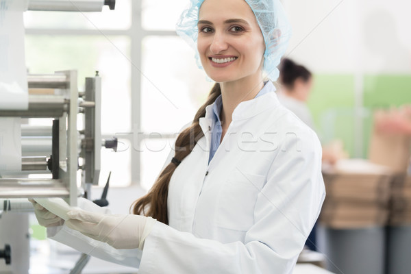 Happy employee wearing lab coat while handling sterile wipes in  Stock photo © Kzenon