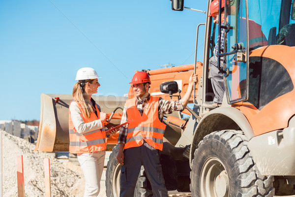 Civil engineer and worker discussion on road construction site Stock photo © Kzenon