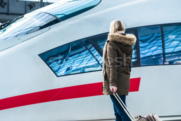 Woman waiting for her train with luggage in station Stock photo © Kzenon
