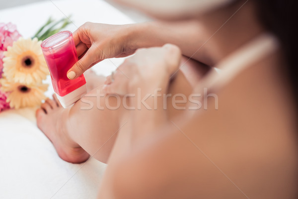 Hand of a young woman using a modern recharchable roll-on waxer  Stock photo © Kzenon