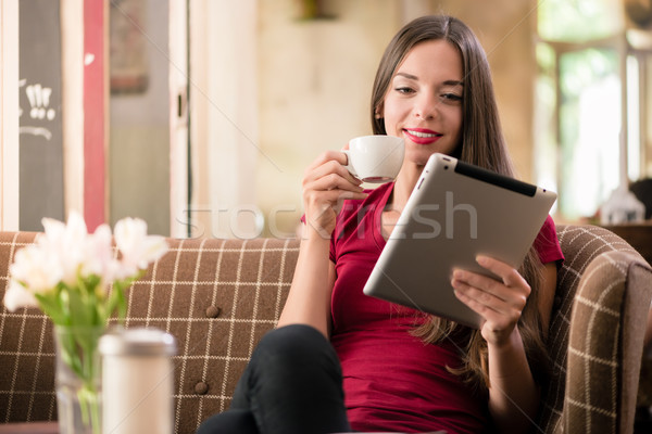 Tijdgenoot jonge vrouw lezing tablet coffeeshop glimlachend Stockfoto © Kzenon