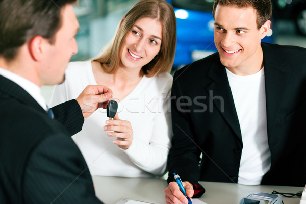 Couple signing sales contract at car dealer Stock photo © Kzenon