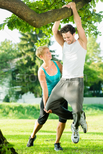 People in city park doing chins or pull ups on tree Stock photo © Kzenon