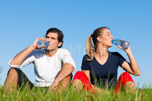 Jogger couple resting and drinking water Stock photo © Kzenon