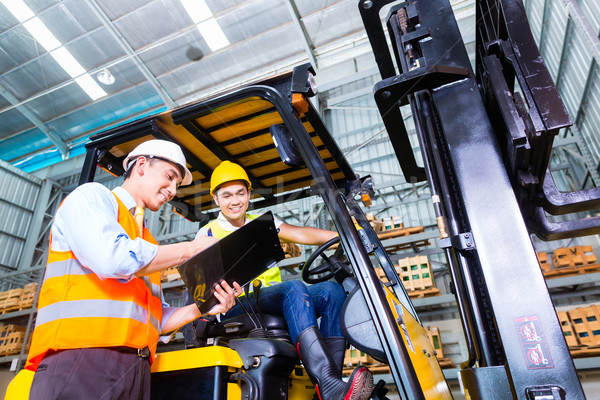 Asian lift truck driver and foreman in storage Stock photo © Kzenon