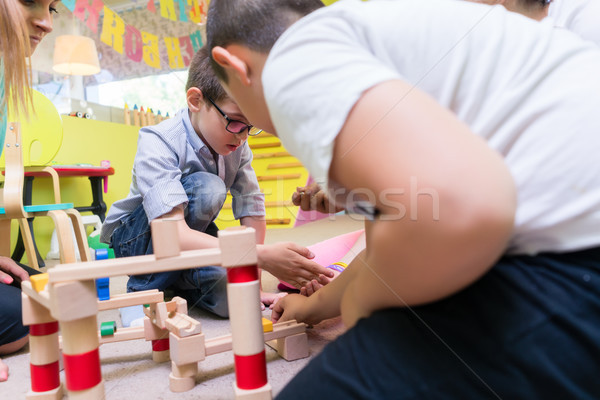 Cute boy building with attention and patience a wooden structure Stock photo © Kzenon