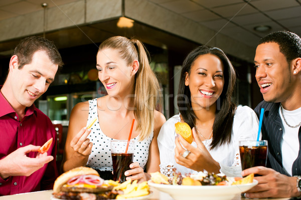 Friends eating hamburger and drinking soda Stock photo © Kzenon