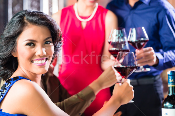 Asian Friends toasting with wine in restaurant Stock photo © Kzenon