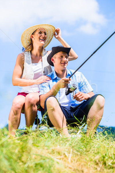 Man with fishing rod angling at lake enjoying hug  Stock photo © Kzenon