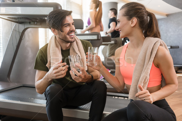 Cheerful young man and woman drinking plain water during break a Stock photo © Kzenon