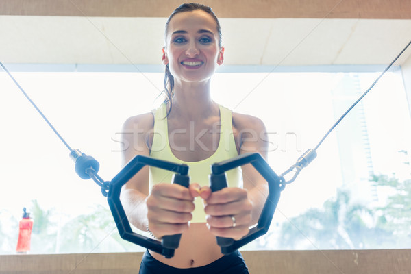 Low-angle view portrait of a cheerful beautiful woman exercising Stock photo © Kzenon