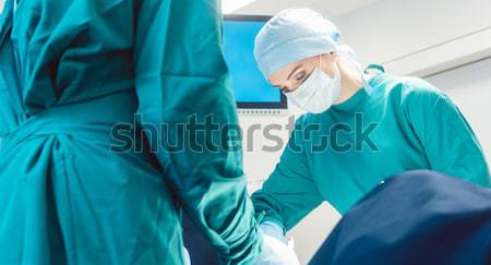 Team of surgeons in operation room during surgery Stock photo © Kzenon