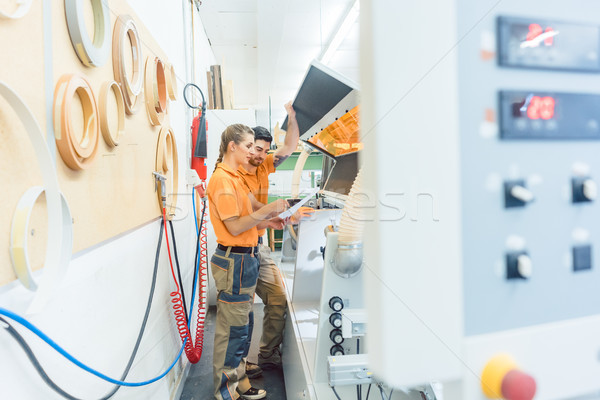 Two carpenters cleaning veneer machine in workshop Stock photo © Kzenon