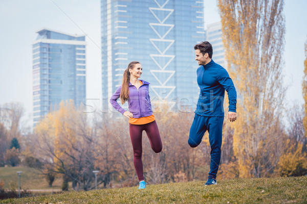 Sport couple doing warm-up exercise before starting a run Stock photo © Kzenon