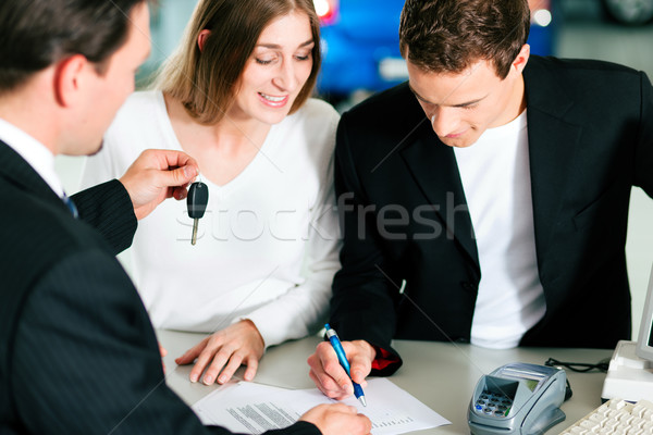 Couple signing sales contract at car dealer Stock photo © Kzenon