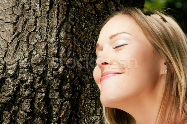 Girl cuddling a tree and dreaming Stock photo © Kzenon